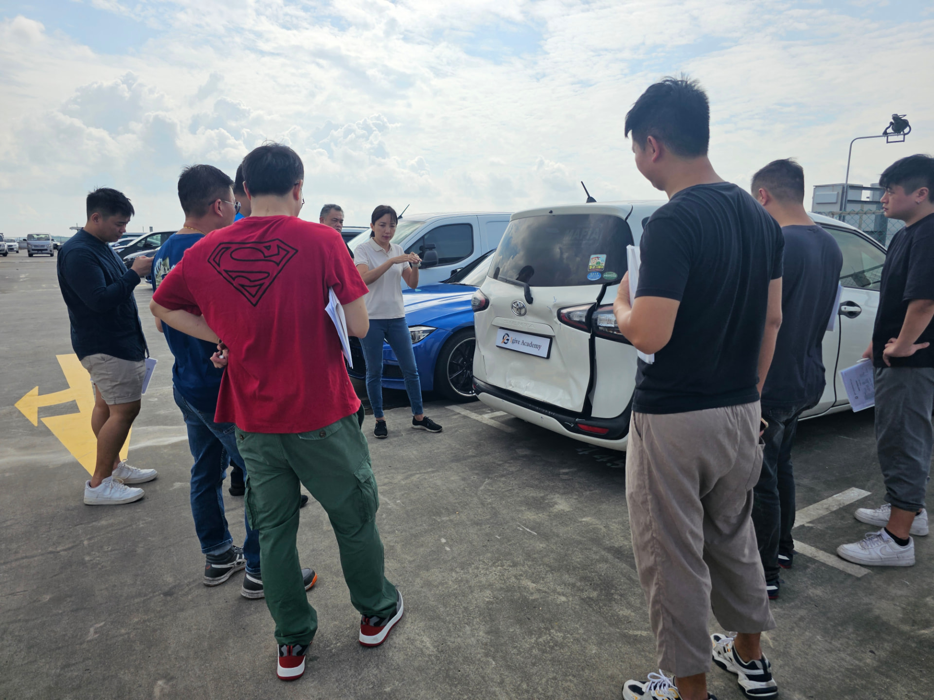 Trainees assessing a real damaged vehicle during on-site practical